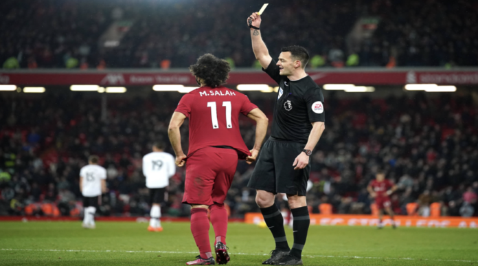 Ο Andy Madley δείχνει κίτρινη κάρτα στον Mo Salah.